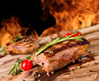 Grilled beef steaks with flames on background