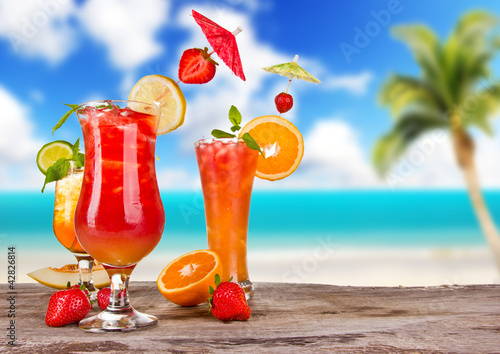 Photo: Summer cocktails with blur beach on background Summer cocktails with blur beach on background
