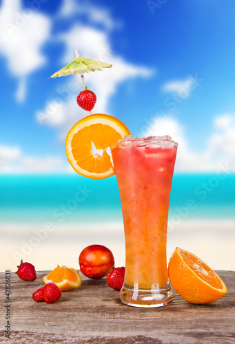 Photo: Summer cocktail with blur beach on background Summer cocktail with blur beach on background