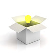 Opened cardboard box with lit light bulb on white