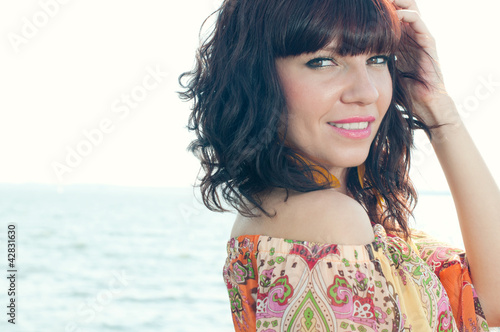 Photo: Horizontal shot of a sensual young woman standing near the shore Horizontal shot of a sensual young woman standing near the shore