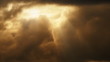 Rays of sunlight stream through gap in heavy storm clouds