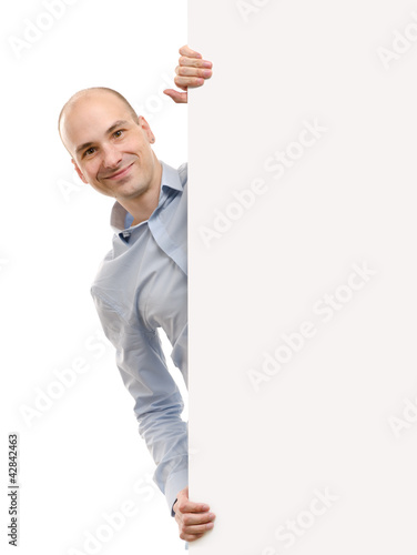 Photo: smiling handsome man posing behind a billboard smiling handsome man posing behind a billboard