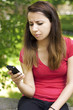 Displeased woman texting on phone