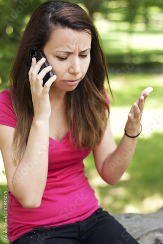 Photo: Upset woman talking on the phone Upset woman talking on the phone