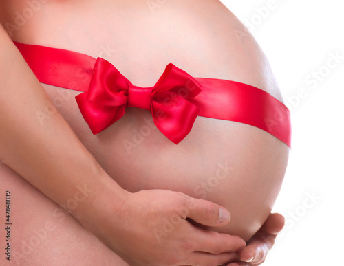Foto: Pregnant Belly with Gift Bow. Pregnancy Pregnant Belly with Gift Bow. Pregnancy
