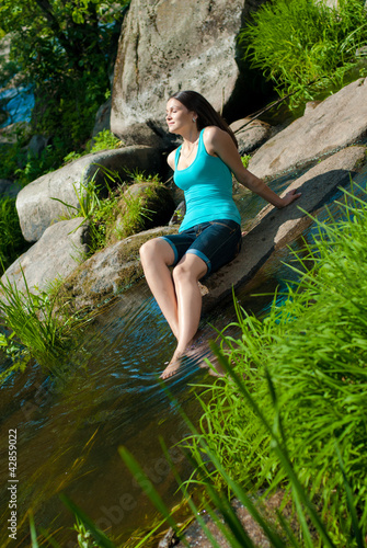 Photo: Young beautiful woman resting on river bank Young beautiful woman resting on river bank