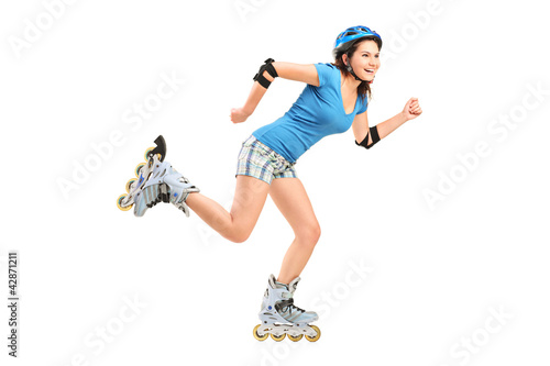 Photo: Full length portrait a smiling girl on rollers skating Full length portrait a smiling girl on rollers skating