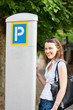 Young woman paying for parking