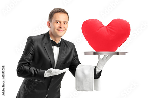 Photo: Butler holding a tray with a red heart shape object on it Butler holding a tray with a red heart shape object on it