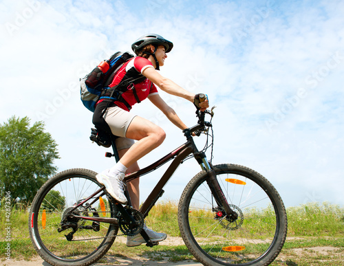 Foto: Happy Young Woman riding bicycle outside. Healthy Lifestyle Happy Young Woman riding bicycle outside. Healthy Lifestyle