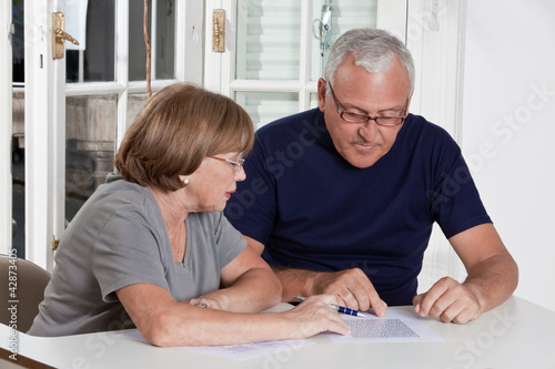 Photo: Mature Couple playing Scrabble Game Mature Couple playing Scrabble Game