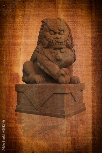 Photo: Chinese statue on the wood texture. Chinese statue on the wood texture.