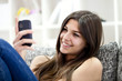 Adorable girl reading message on phone