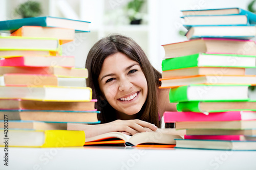 Photo: teenage girl between stack of book teenage girl between stack of book