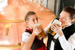 Photo: Paar in Tracht mit Bier Glas in Brauerei Paar in Tracht mit Bier Glas in Brauerei