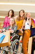 Four female friends shopping in a mall with wheelchair