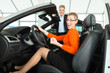 Young woman in seat of auto in car dealership