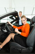 Young woman in seat of auto in car dealership