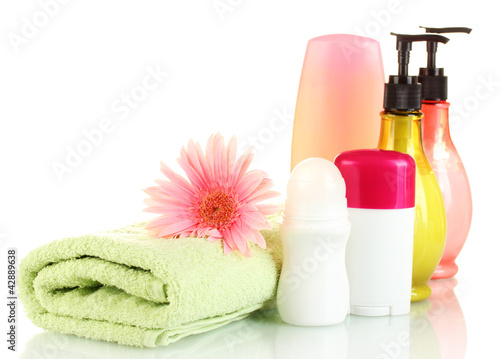 Photo: cosmetics bottles with towels and flower isolated on white cosmetics bottles with towels and flower isolated on white