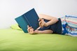 Photo: woman reading on green sheet woman reading on green sheet