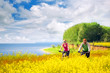 happy couple cycling in canola fields