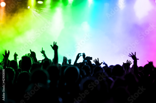 Photo: cheering crowd in front of colorful stage lights cheering crowd in front of colorful stage lights