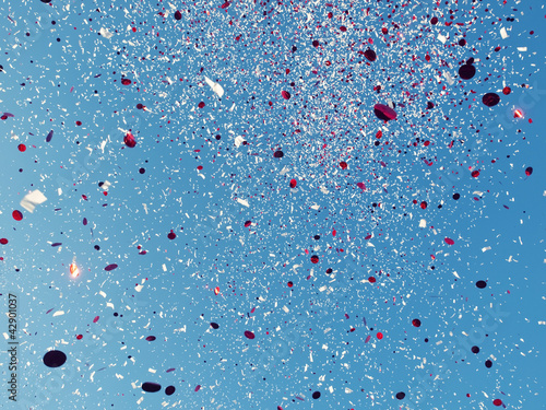 Photo: Red and White confetti against a blue sky Red and White confetti against a blue sky