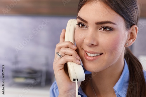 Photo: Happy woman on landline call Happy woman on landline call