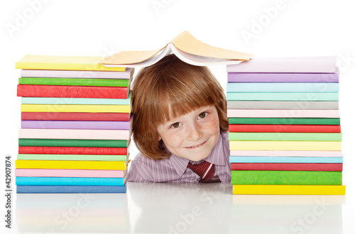 Photo: School boy with lots of colorful books School boy with lots of colorful books