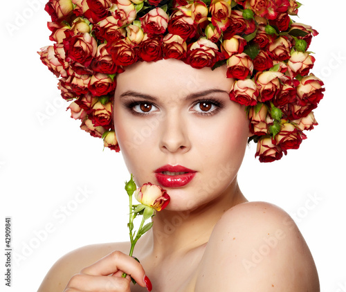Foto: Portrait of young beautiful woman with roses in hair, on white b Portrait of young beautiful woman with roses in hair, on white b