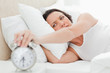 Woman turning off her alarm clock 