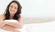 Close-up of a beautiful young brunette sitting in her bed