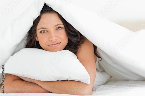 Photo: Smiling woman hugging a pillow Smiling woman hugging a pillow