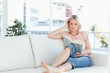 Female lying on a sofa while reading a book