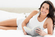 Brunette reading a book on her bed