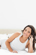 Close-up of a brunette smiling while phoning 
