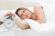 Young woman turning off her alarm