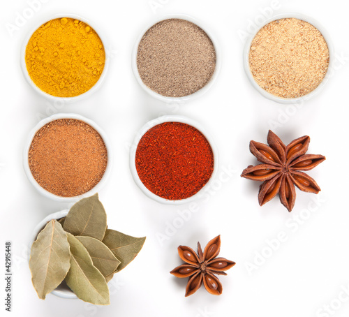 Photo: Different spices in white bowls isolated on white background. Different spices in white bowls isolated on white background.