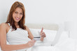 Redheaded woman approving while shopping online on her laptop