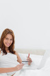 Redheaded approving the shopping online while sitting on her bed