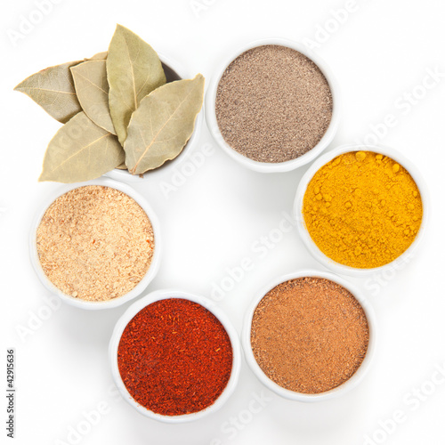 Photo: Different spices in white bowls isolated on white background. Different spices in white bowls isolated on white background.