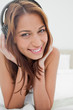 Foto: Green eyes woman lying on her belly while listening to music Green eyes woman lying on her belly while listening to music