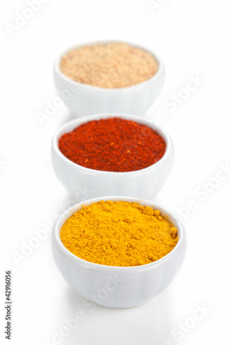 Photo: Different spices in white bowls isolated on white background. Different spices in white bowls isolated on white background.
