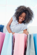 Laughing fuzzy hair woman looking into her shopping bags