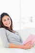 Portrait of a beaming woman with a novel