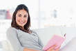 Portrait of a smiling woman with a novel