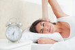 Brunette waking up by her alarm 