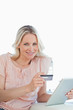 Portrait of a blonde buying online with a touchpad