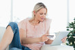 Blonde woman buying online with a touchpad